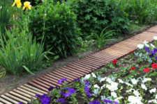 18 a simple and cute garden path made of pallet wood and painted in different colors
