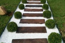 22 a stained wood garden path with white gravel and boxwood looks very formal, elegant and inviting