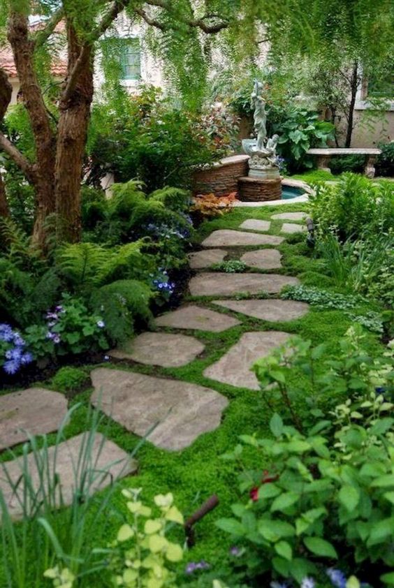 a stone front yard pathway with moss in between and around for a welcoming and beautiful space
