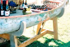 24 a vintage canoe boat turned into a drink station on stands can accommodate a lot of drinks and appetizers