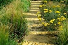 25 a wooden and sea shell garden path lined up with greenery and bright blooms is ideal for a beach garden