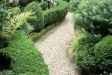 a chic neutral-colored gravel pathway with brick lining in a lush garden is a cool idea that allows drainage