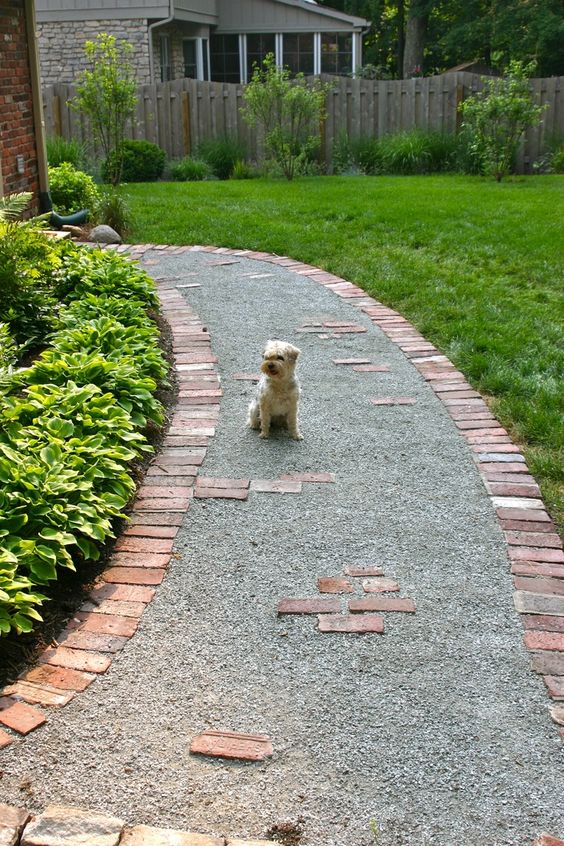 a gravel pathway lined with red bricks is a stylish and timeless idea, and your gravel won't finish on the lawn