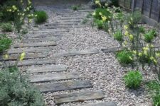 a gravel pathway with some reclaimed wood steps, greenery and blooms around is a cool idea for a rustic outdoor space