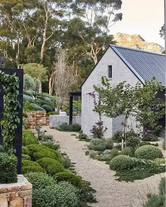 a lovely modern farmhouse garden with greenery and shrubs, with gravel pathways is a cool idea to steal
