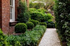 a modern and elegant side yard with a grave path, greenery and shrubs is a stylish solution for a modern home