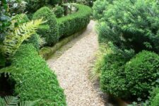 a super lush greenery garden with shrubs and greenery and trees around and a gravel pathway are a lovely combo