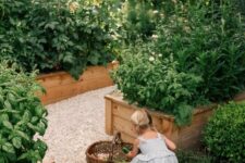 a veggie garden with raised garden beds with wood edging and a gravel pathway is a cool and lovely space