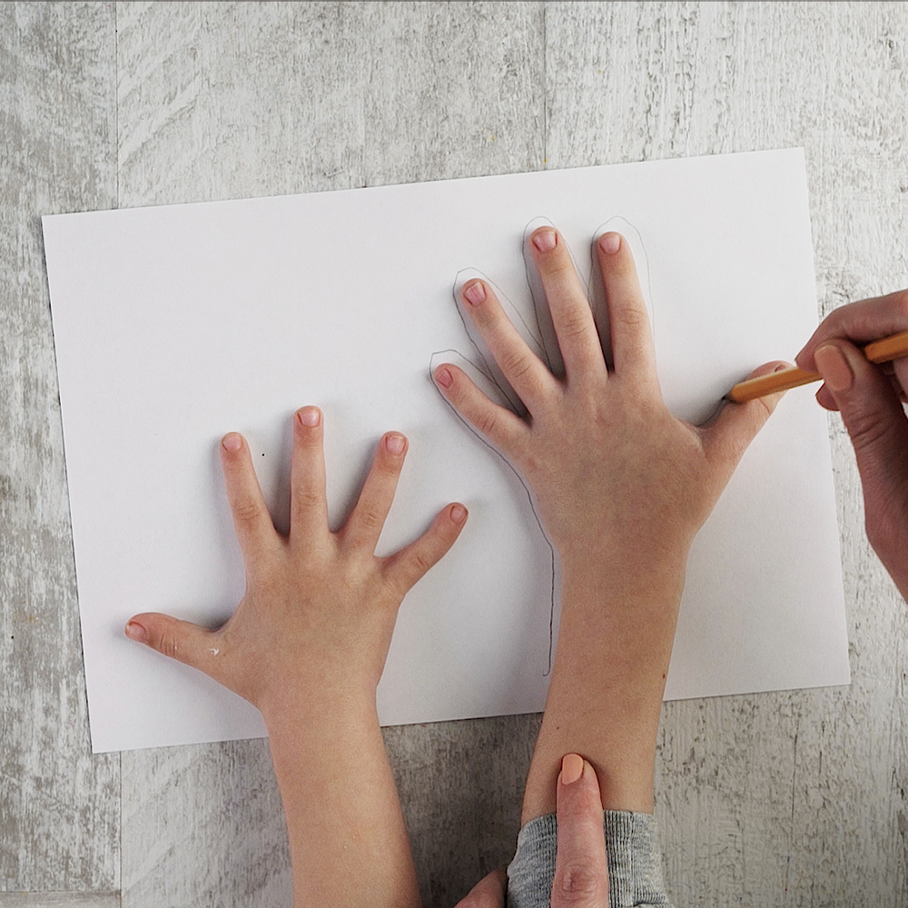Trace the kids’ hands on paper, attach this sheet to a plywood sheet using a glue stick.
