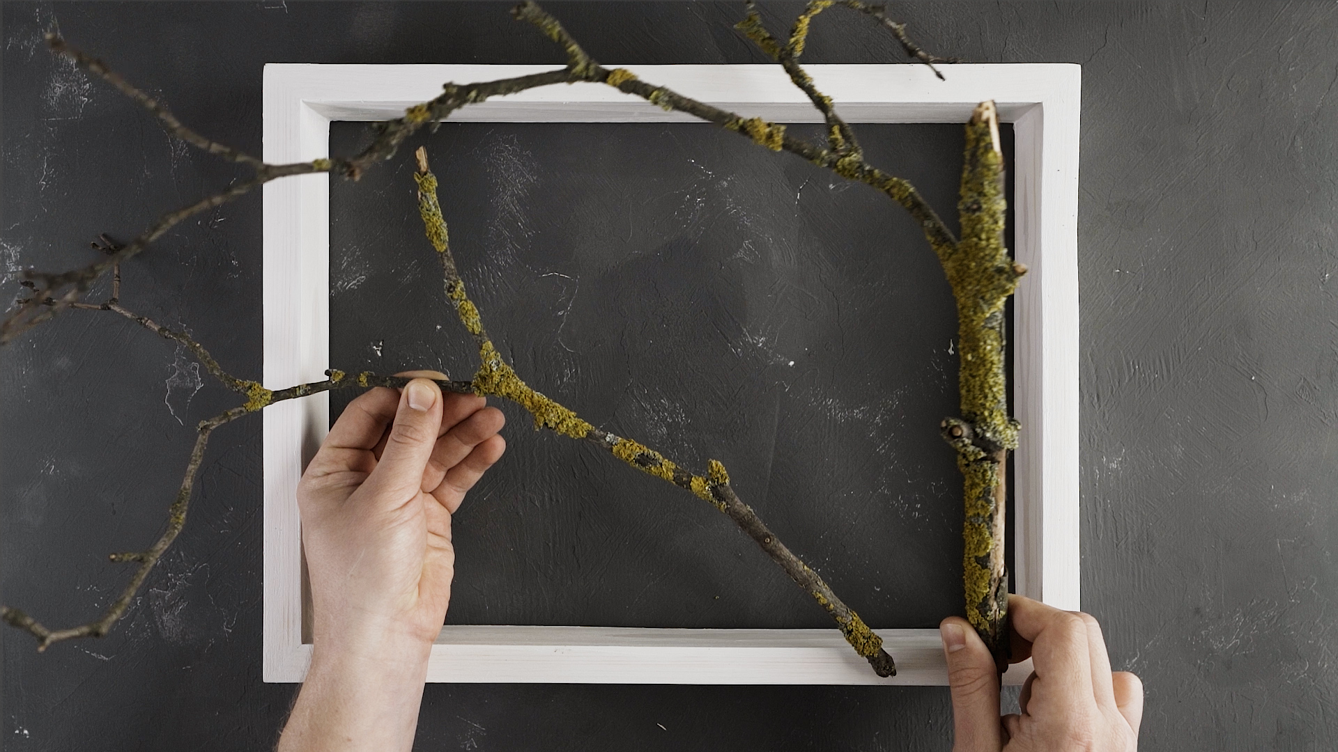 Find proper branches (better with moss on them for a more natural look) to fit your frame.