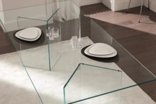 09 a minimalist dining table with geometric glass legs and a glass tabletop seems to be floating in the air