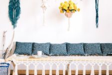 15 a modern macrame daybed with tassels, blue printed pillows and colorful macrame hangings for planters