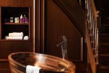 16 a wooden oval bathtub with metal fixtures looks elegant and chic in a wooden bathroom