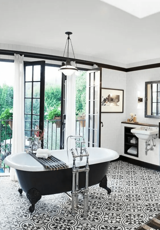 a 20s inspired bathroom in black and white with an oval black clawfoot tub on legs
