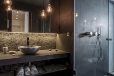 a matta black contemporary bathroom with a shower, pendant lamps, a concrete vanity and a vessel sink