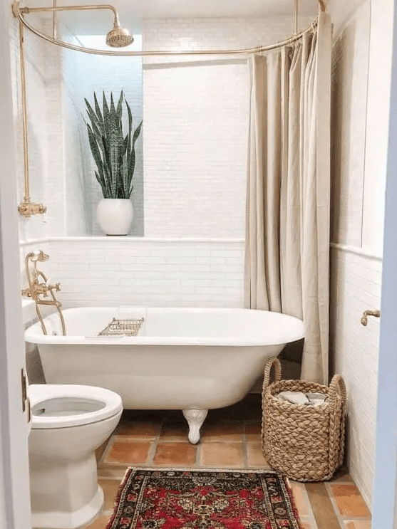 a tiny and lovely bathroom with a clawfoot tub, a potted plant, a sink and a toilet, a basket and nothing else