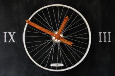 DIY bike wheel clock with Roman numbers on the wall