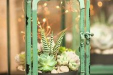 10 a green vintage lantern with a succulent garden, pebbles and LED lights over it