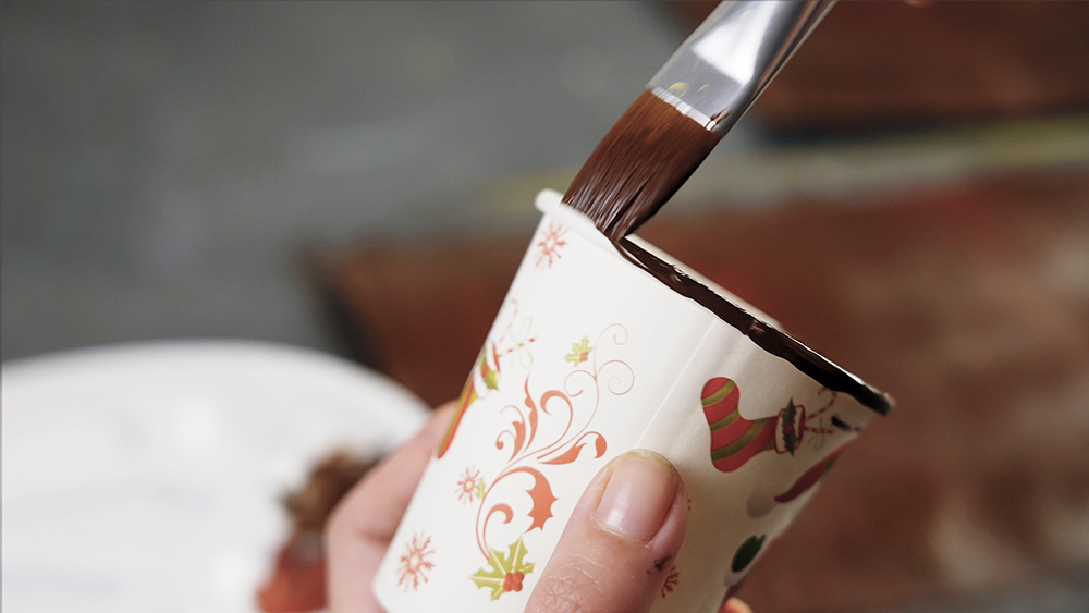 Paint the edge of a plastic cup in brown and when they all dry, wrap the plastic cup with these sheets of paper.