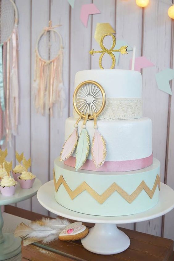 a pastel baby shower cake in boho style, with an edible dream catcher and arrows