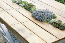 16 an outdoor pallet dining table with a planter in the center and lots of green and purple succulents inside
