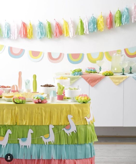 Fiesta birthday party done with paper cacti, colorful banners and garlands and a fringed paper tablecloth