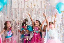 colorful Superhero themed party for girls with bright costumes and lot sof glitter and confetti