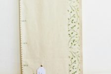 DIY fabric growth chart with tags on decorative nails