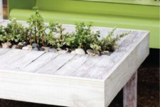 DIY wooden patio cocktail table with a planter in the center