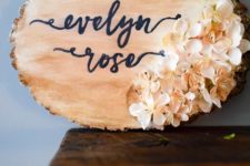 DIY nursery wood sign of a wood slice and with fake blooms