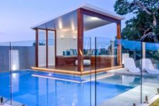 02 a contemporary cabana by the pool with a stained wooden bench, colorful pillows and lights