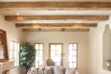 rough wooden beams with lights and a wooden table for creating a Provence-inspired space with a cozy rustic feel
