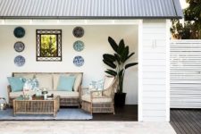 17 a tropical and beach-inspired pool cabana with decorative plates, rattan furniture, a potted plants and touches of blue