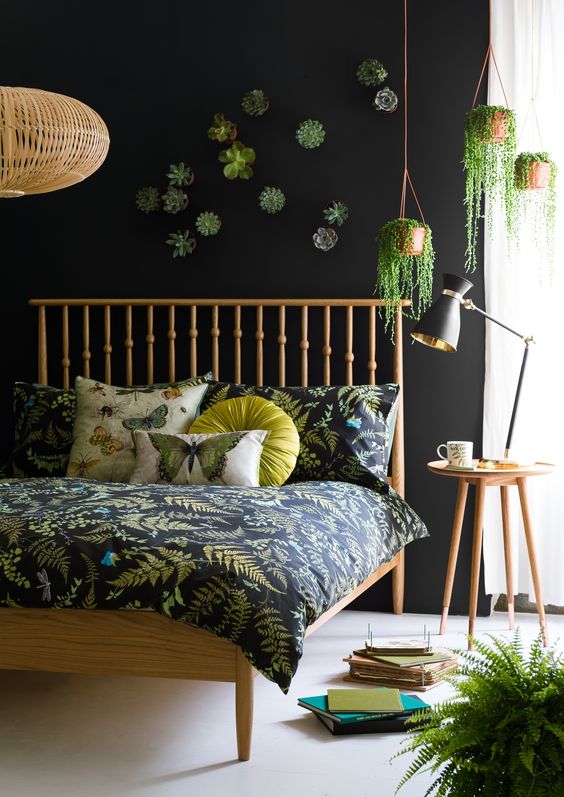 a moody boho bedroom with a dark botanical print bedding set and wood and wicker touches