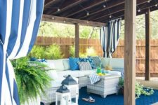 21 a gorgeous pool cabana done in blues and white with wicker furniture, lanterns and rugs plus potted ferns