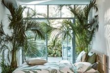 21 a light-filled bedroom with palm trees in pots and matching bedding plus a garden behind the wall