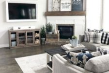 a farmhouse living room done in neutrals, with grey upholstered furniture, a rustic coffee table, a gallery wall on the mantel