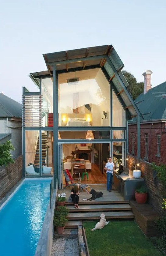 a leveled backyard with a lawn and a narrow pool uses the whole space effectively