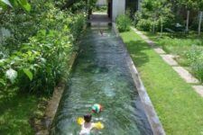 a long and narrow pool clad with stone is integrated right into the garden to make it feel lively and very natural