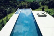 a minimalist outdoor space with a sleek deck, a long and narrow infinity pool plus a jaw-dropping view