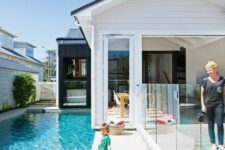 a pretty modern backyard with a stone deck, a small pool, a glass fence to make the zone safe