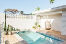 a welcoming natural backyard with a plunge pool clad with printed tiles, rattan furniture and planted cacti and succulents