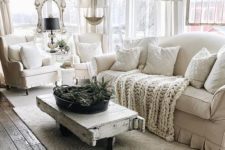 a white farmhouse living room with a shabby chic coffee table, shabby details and neutral textiles