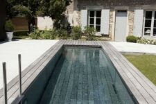 an outdoor space with a long and narrow pool and a wooden deck around is a lovely space to have a rest when it’s hot