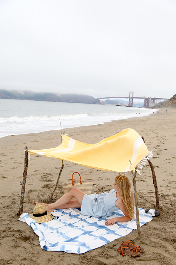 DIY boho beach tent of sticks and a shower curtain (via sayyes.com)
