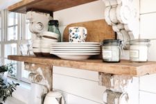 14 white shiplap walls and naturally stained wooden shelves make up a chic and cool farmhouse kitchen