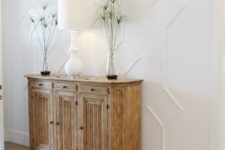16 elegant white paneling highlights the farmhouse style of this entryway and helps to avoid boring looks