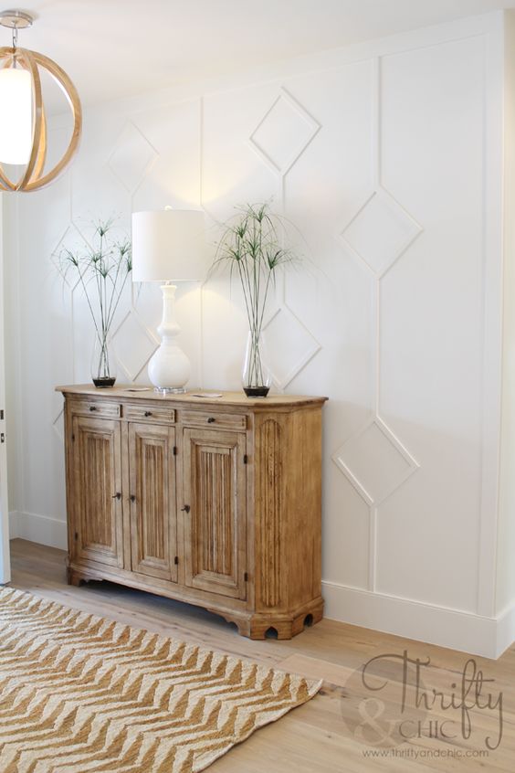 elegant white paneling highlights the farmhouse style of this entryway and helps to avoid boring looks