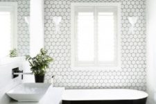 21 white hexagon tiles are highlighted with black grout in this minimalist bathroom