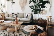 a bohi chic living room with a printed rug and pillows, a macrame hanging, potted plants and jute ottomans